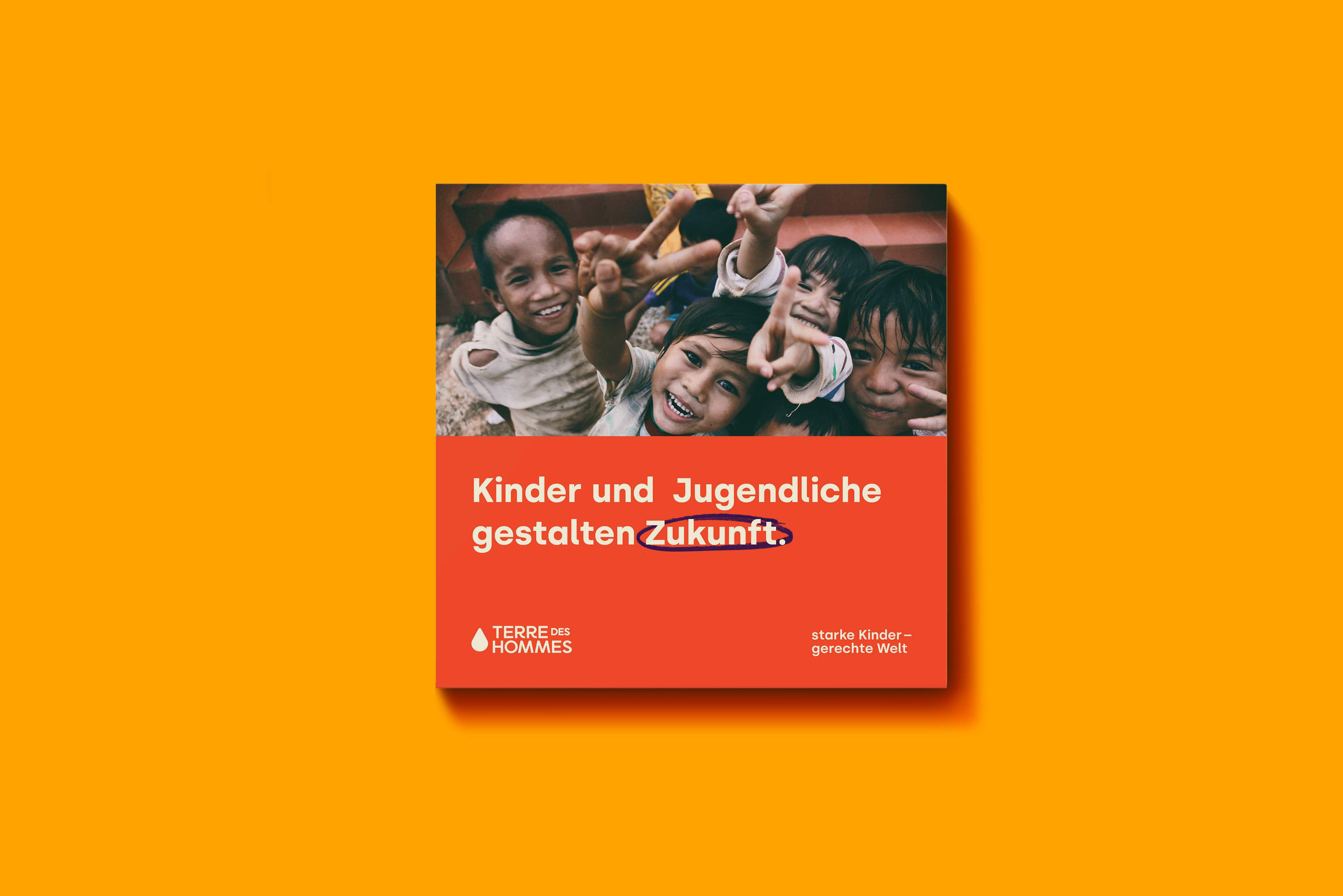 Das Bild zeigt lachende Kinder, die fröhlich in die Kamera schauen. Darunter steht auf einem orangefarbenen Hintergrund der Text: 